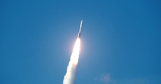 Nice shot of commercial Space Rocket with bright flames and exhaust smoke flying into the clouds. 4K at  120 fps slow motion.