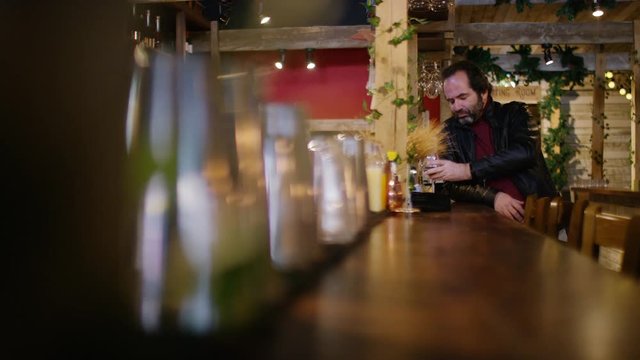 Older mature male at the bar drinking by himself
