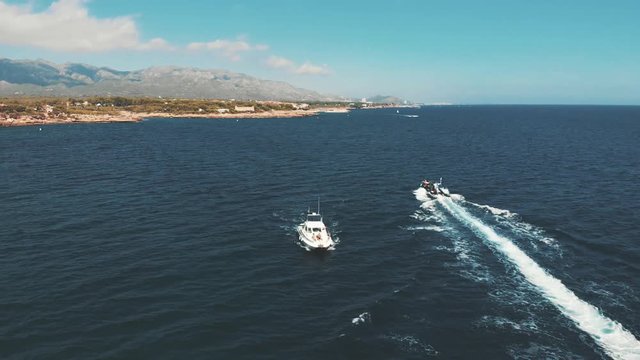 Front aerial view of a yacht sailing through the sea.