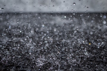 Close Up Macro Photo of Water Drops Falling and Splashing on Black Tile - with Droplets Frozen in...