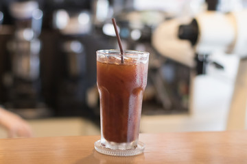 Iced Americano coffee.Background with coffee machine and barista.