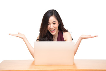 Excited young asian girl using laptop computer and celebrating success on wood table isolated over white background