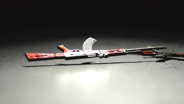 SLOW MOTION:&nbsp;Two Ak-47 Kalashnikov&nbsp;falls down on a&nbsp;black surface