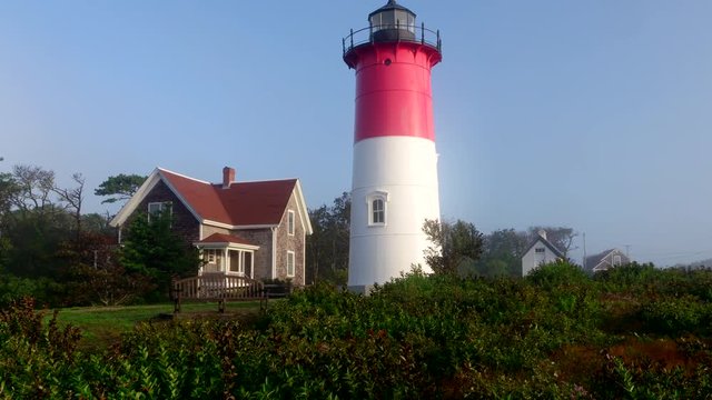 Scenic Nauset lighthouse in fog - camera tilts up.