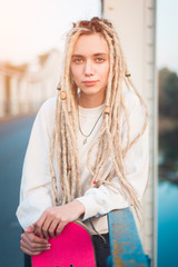 Young woman with skate portrait on the bridge