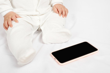 Baby holding a mobile phone isolated on white background