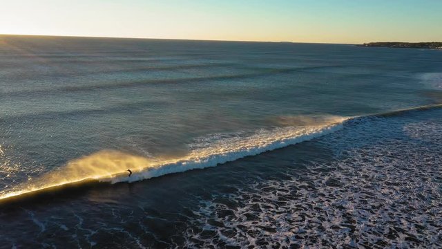 Aerial Footage Flying Along A Wind Whipped Wave And A Surfer Braving The Cold December Morning In York Beach Maine With Lens Flare