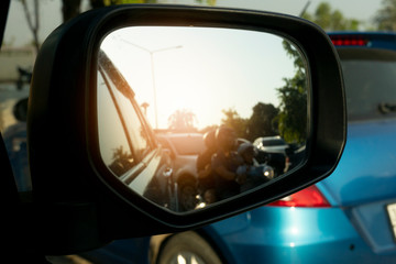 Cars run through the street from the car's side view mirror.
