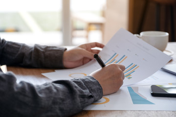 A businesswoman writing and working on business data and document on the table in office