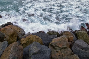 View from Mission Beach in San Diego, of Piers, Jetty and sand, around surfers, including warning signs, palm trees, waves, rocks, boats and horizon views. Pacific Ocean. California, United States.