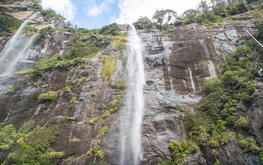 Beautiful high waterfalls in Milford Sound national park in south island of New Zealand. Milford Sound is known as the land of a thousand waterfalls. 