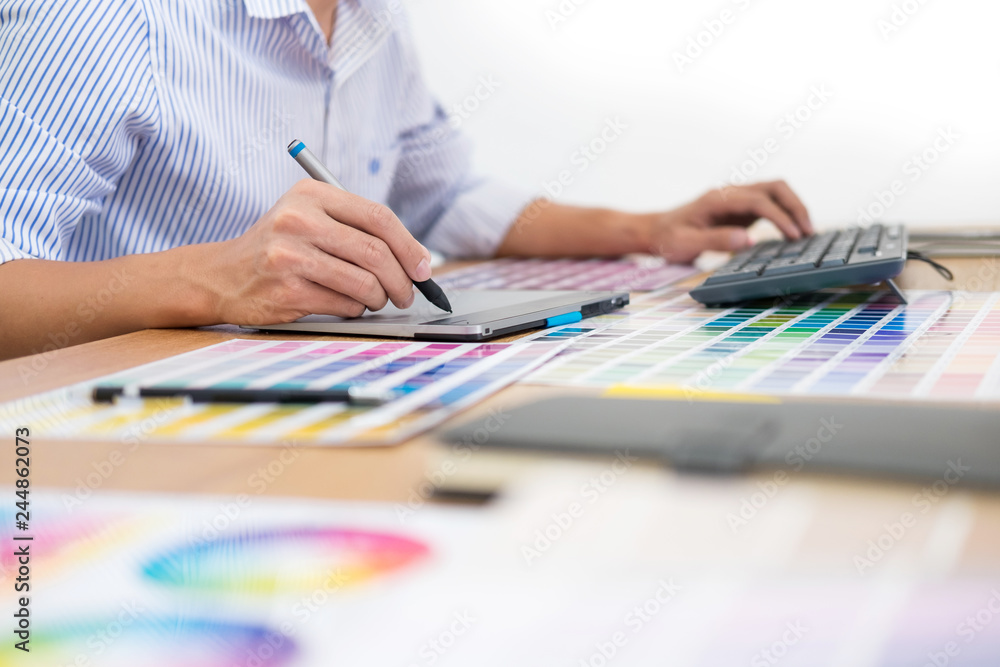 Aufkleber designer editor at work drawing sketches a new project on graphic tablet and color palette sitting a