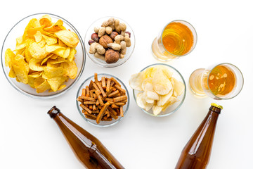 Snacks and beer. Chips, nuts, rusks near beer on white background top view