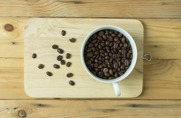 Coffee bean in cup on wooden table,selective focus.