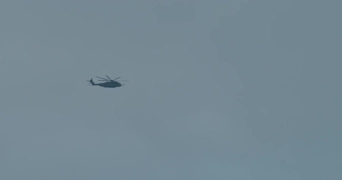 Huge military helicopter flying at a distance over a battlefield in Afghanistan