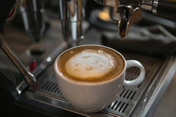 Cup of coffee with baby face cream on top