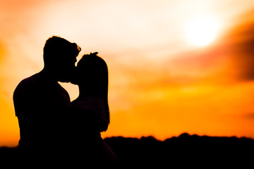 couple kissing at sunset