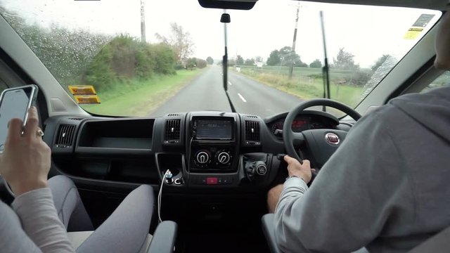 View from inside of a van - couple driving in a rainy weather in New Zealand