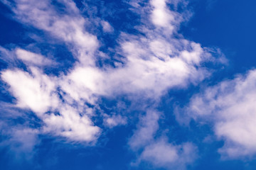 Blue sky with white and purple clouds.