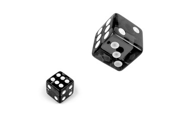 Two black glass dices isolated on white. Six and flying in the air, view from above.