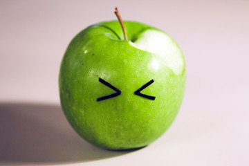 bitten dissatisfied apple. fruit with eyes. 