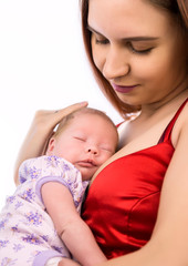 Pretty woman holding a newborn baby in her arms on a white background