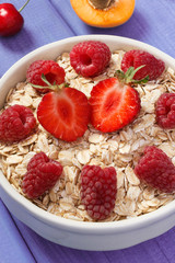 Oat flakes with fresh ripe fruits in glass bowl, healthy lifestyle and nutrition