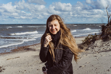 girl walking along the beach of the cold Baltic Sea