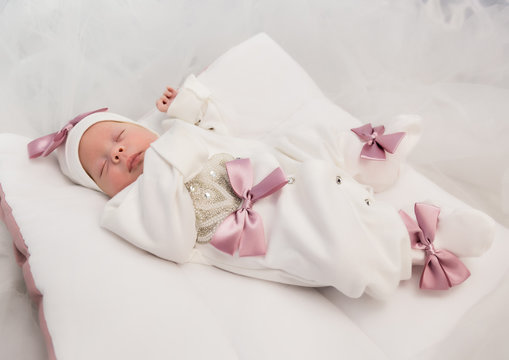 sleeping newborn baby in a wrap lying on a warm blanket