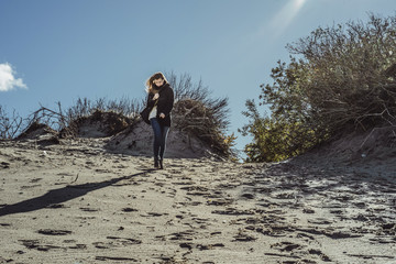 girl walking along the beach of the cold Baltic Sea
