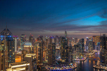 Panoramic view over famous Dubai Marina skyline. Colorful background with modern skyscrapers and glittering night lights