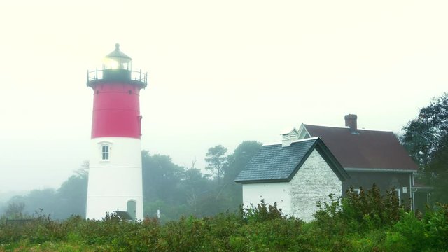 Lighthouse with beacon spinning on foggy day. Nauset Lighthouse, Cape Cod.