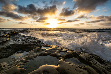 Obraz premium Rocky coast at dusk with crashing waves 