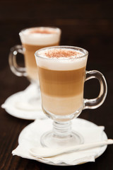 Cappuccino with cinnamon. Cup of coffee on wooden background