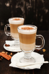 Cappuccino with cinnamon. Cup of coffee on wooden background