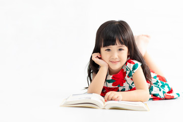 smiling little  girl with book lying on the floor