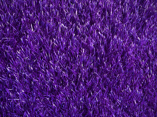 beautiful artificial fur rough texture purple color, charming colorful texture glowing background for party decoration board, shiny violet color of artificial grass mat, close up purple carpet