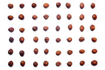 A collection of hazelnuts  lie in straight rows along dioganals on an isolated white background. with clipping path. Hazelnuts  pattern