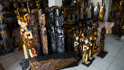 Hindu and Buddhist wooden carving. souvenir shop selling souvenirs and handicrafts of Bali at famous Ubud Market, Indonesia