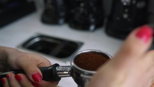 Barista shakes portafilter with ground coffee