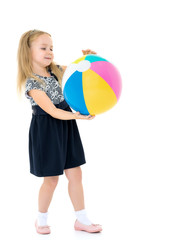 Fototapeta premium Little girl is playing with a ball