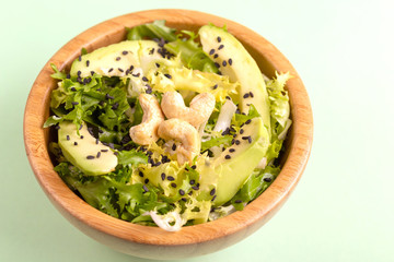 Tasty salad with frisee, avocado, cashew nuts and black sesame