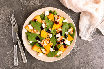 Exotic salad with spinach, persimmon, grilled chicken fillet, feta