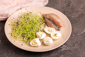 Unusual salad with leek sprouts, quail eggs and anchovies