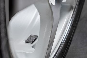 A fragment of the wheel of a car with a balancing weight