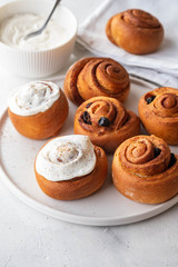 Delicious Cinnamon Rolls with cheese cream on a white plate. Copy space.