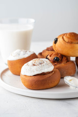 Delicious Cinnamon Rolls with cheese cream on a white plate. Copy space.