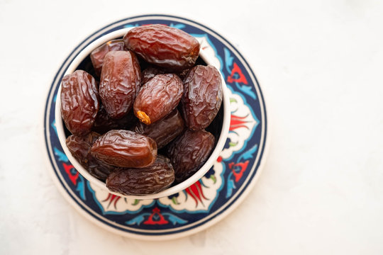 Fresh Medjool Dates in a bowl. Ramadan kareem. White background. Turkish style. Top view. Copy space.