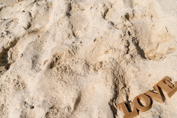 3D Letters of LOVE on the sand background