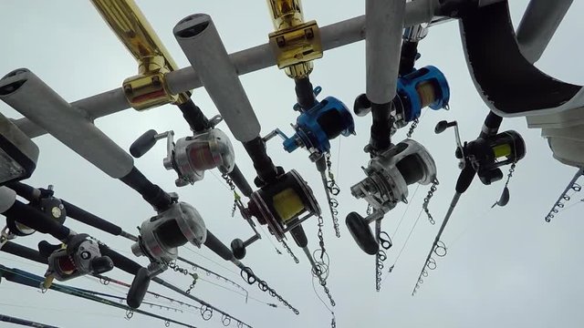 Fishing rods shot from the ground up on a moving boat. SLOW MOTION.